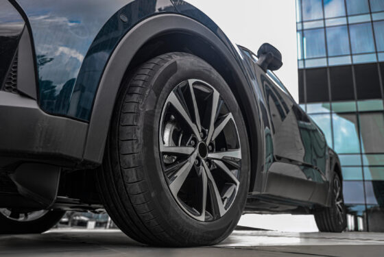 wheels with tires and aluminium rims. Parked car model, in gray metallic color, with 1.8-liter hybrid engine Low angle view wheels with tires and aluminium rims. Parked car model, in gray metallic color, with 1.8-liter hybrid engine Low angle view